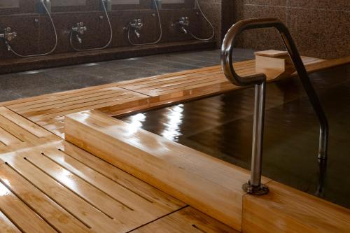 a bathtub in a room with a wooden floor at Shinzan Kinosaki in Toyooka
