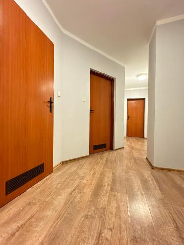 an empty room with two doors and wooden floors at Ząbkowickie Centrum Sportu i Rekreacji Sp. z o. o. in Ząbkowice Śląskie