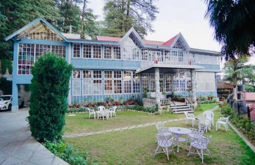 un grande edificio con tavoli e sedie di fronte di The Heritage Shimla by Boho Stays a Shimla