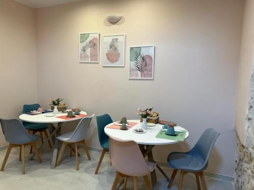two tables and chairs in a room with paintings at Il viandante in Sulmona