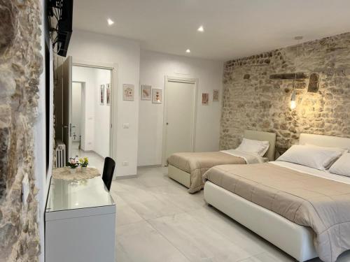 a bedroom with two beds and a table in it at Il viandante in Sulmona