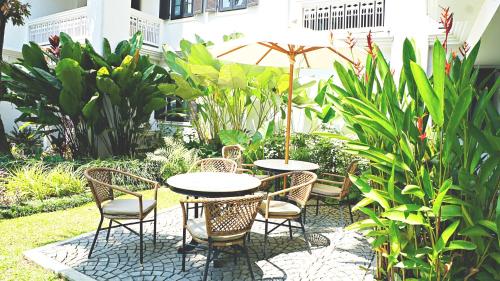 a patio with a table and chairs and an umbrella at Buri Sriping Riverside Resort & Spa in Chiang Mai