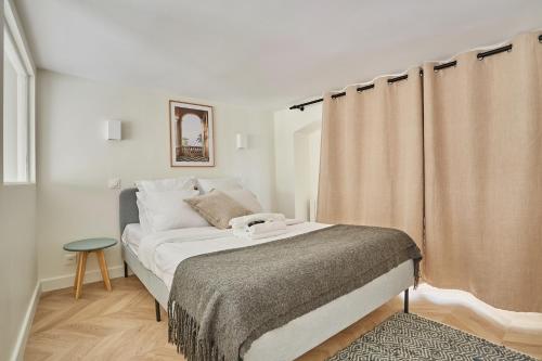 - une petite chambre avec un lit et un rideau dans l'établissement Apartment Saint Germain des prés by Studio prestige, à Paris