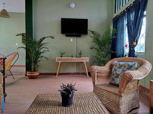 un soggiorno con 2 sedie e una TV di Casa Macondo a Tocaima