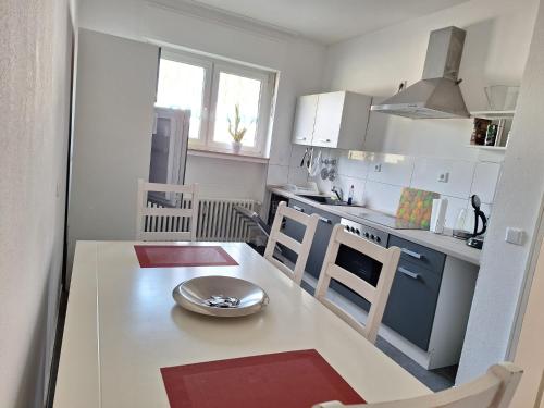 eine kleine weiße Küche mit einem Tisch und Stühlen in der Unterkunft Helle 3 Zimmer Wohnung in Krefeld