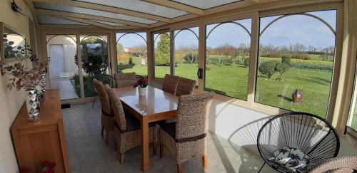 une véranda avec une table et des chaises dans l'établissement Gîte 