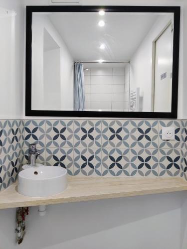 uma casa de banho com um lavatório e um espelho em Studio avec jardin proche de la Défense em Courbevoie