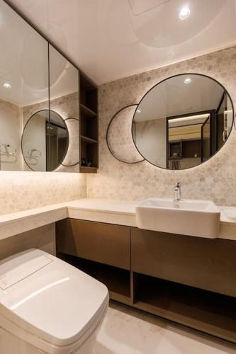 a bathroom with a toilet and a sink and a mirror at Wecostay Gangnam in Seoul