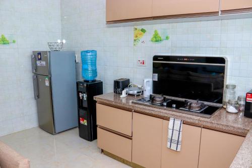 uma cozinha com um frigorífico, um fogão e um micro-ondas em Spring Garden By Edmor Suites em Nairobi
