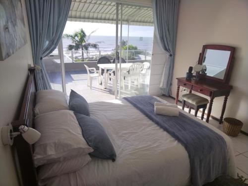 a bedroom with a bed with a view of the ocean at Libra Holiday Flats 1 in Margate