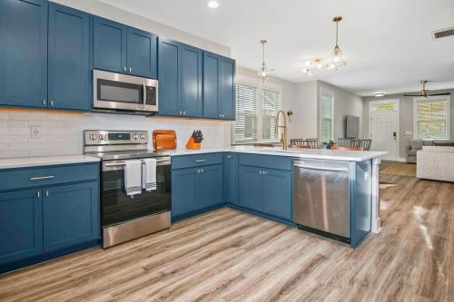 uma cozinha com armários azuis e electrodomésticos de aço inoxidável em Penny Lane Park Circle 15m dwtn CHS em Charleston