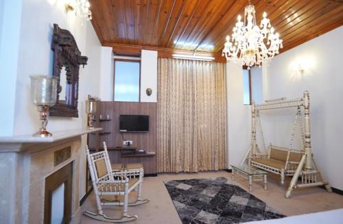 uma sala de estar com lareira e um lustre em The Heritage Shimla by Boho Stays em Shimla