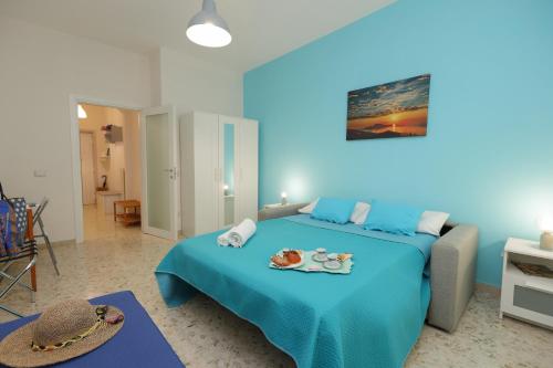 - une chambre bleue avec un lit doté d'un chapeau dans l'établissement La Coccinella Sorrento, à Sorrente