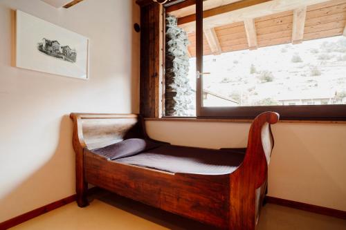 a chair sitting under a window in a room at Maison Rosset agriturismo, camere, APPARTAMENTI e spa in Valle d'Aosta in Nus