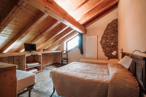 a bedroom with a bed and a tv in a room at Maison Rosset agriturismo, camere, APPARTAMENTI e spa in Valle d'Aosta in Nus