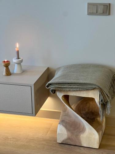 a living room with a bed and a table with a candle at Cozy Designer Apartments, Self Check-In & FREE Parking in Klaipėda
