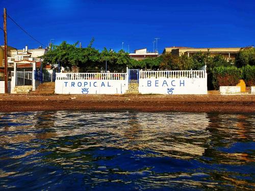 a white fence next to a body of water at Tropical Beach "Nereus" in Petalidhion