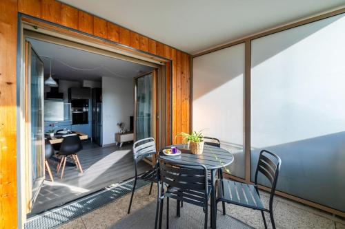 une pièce avec une table et des chaises sur un balcon dans l'établissement New Splendid Appt Terrace - 5 min Disneyland Paris, à Montévrain