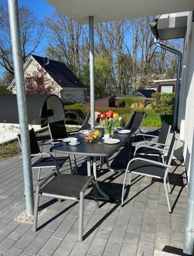 a table and chairs under an umbrella on a patio at Haus Water Jieper in Göhren-Lebbin