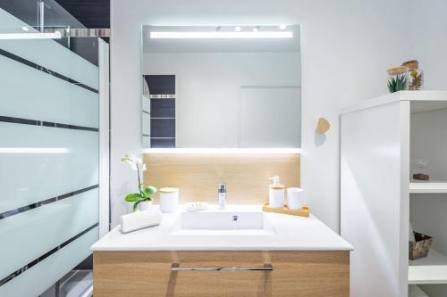 a bathroom with a white sink in a room at New Splendid Appt Terrace - 5 min Disneyland Paris in Montévrain