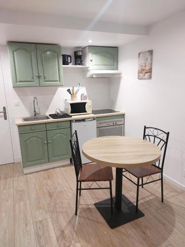 a kitchen with green cabinets and a table and chairs at Studio avec jardin proche de la Défense in Courbevoie