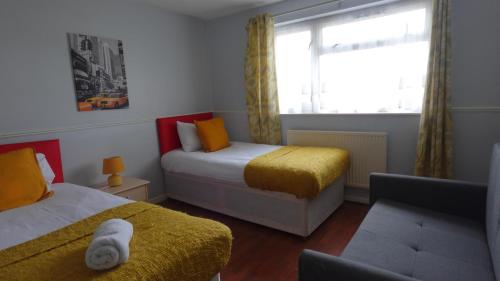 a small bedroom with two beds and a window at Chelsea House-Huku Kwetu Dunstable-3 Bedroom House - Suitable & Affordable -Business Travellers - Group Accommodation - Comfy, Spacious with Lovely Garden Views in Houghton Regis