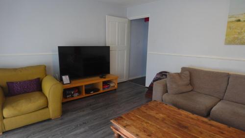 a living room with two couches and a flat screen tv at Chelsea House-Huku Kwetu Dunstable-3 Bedroom House-Garden-Free Wifi-Private parking in Houghton Regis
