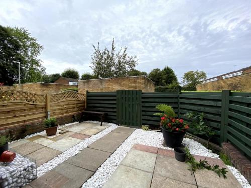 a garden with a fence and a patio at Chelsea House-Huku Kwetu Dunstable-3 Bedroom House-Garden-Free Wifi-Private parking in Houghton Regis