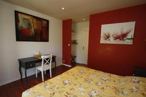 a bedroom with a bed and a desk and a table and a chair at Demeure de Flore in Lacabarède