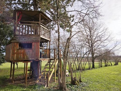 une cabane dans les arbres avec une échelle dans un arbre dans l'établissement L échappée belle en campagne charentaise, à Gondeville