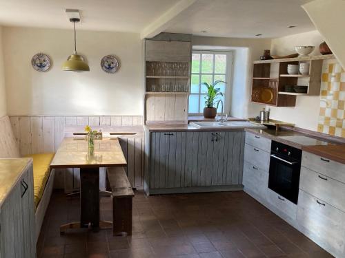 a kitchen with a wooden table in the middle at Whichford Mill Barn- Soulful retreat. in Shipston on Stour