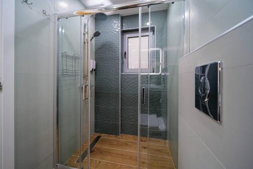 y baño con ducha y puerta de cristal. en Sea Vibes in the City Center, en Atenas