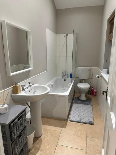 a bathroom with a sink and a tub and a toilet at Dublin Airport Homestay in Dublin