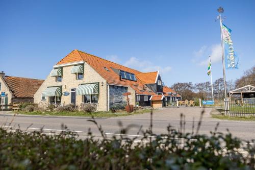 a building on the side of a street with a flag at De Cyprian Bed & Breakfast in Baaiduinen