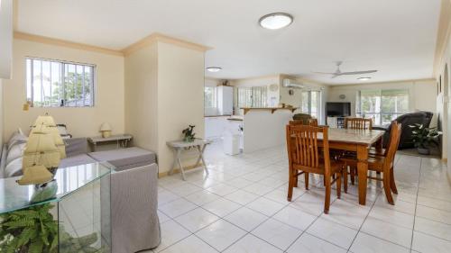 a kitchen and living room with a table and chairs at Enjoy Sunsets and Waterviews from your private Balcony in Bellara