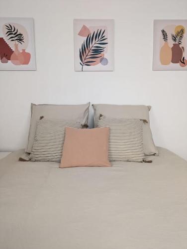 a white bed with two pillows and avertisement at Rouen Centre historique in Rouen