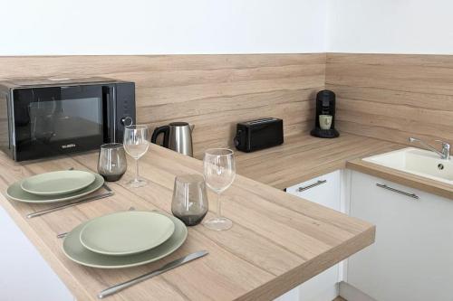 une cuisine avec une table avec des assiettes et des verres à vin dans l'établissement Rouen Centre historique, à Rouen