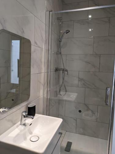 une salle de bain blanche avec une douche et un lavabo dans l'établissement Rouen Centre historique, à Rouen