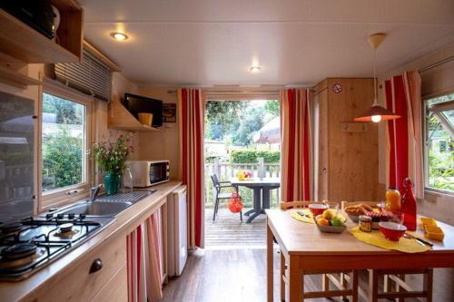 a kitchen with a counter and a table with fruits on it at LES ROULOTTES DU MOULIN in Confort