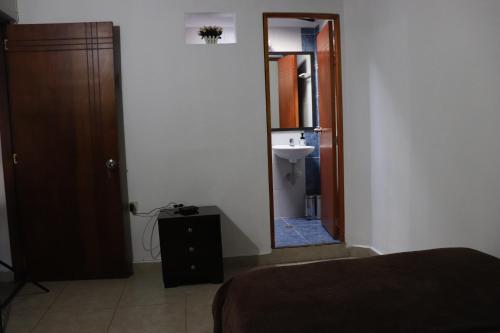 La salle de bains est pourvue d'un miroir, d'un lavabo et d'un lit. dans l'établissement Medellin My Home, à Medellín