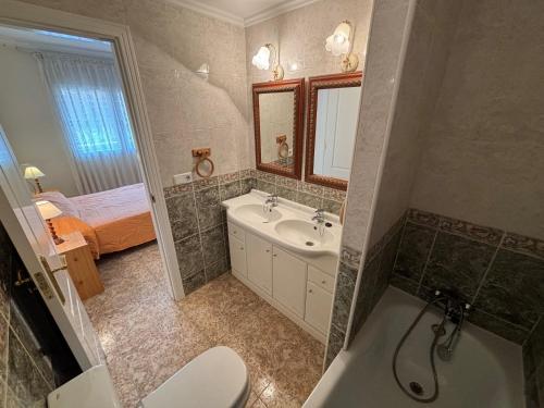 a bathroom with a toilet and a sink and a tub at Vistamar 2-Serviden in Denia