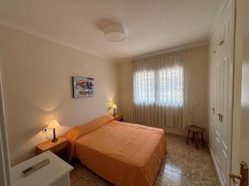 a small bedroom with a bed and a window at Vistamar 2-Serviden in Denia