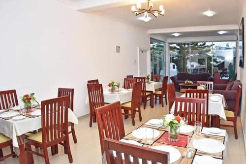 a dining room with white tables and chairs at American Star Hotel- Nuwaraeliya in Nuwara Eliya