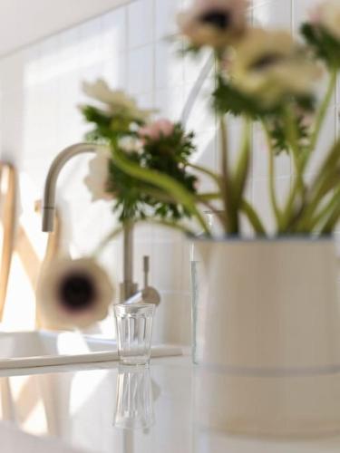 un verre sur une table avec un vase de fleurs dans l'établissement Le 6 _ Appartement d'exception, à Vence