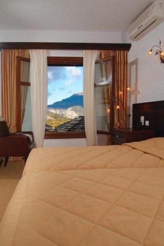 a bedroom with a large bed and a window at Hotel Taxiarches in Aristi