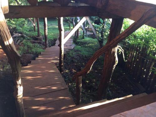 a wooden pathway with a wooden fence and trees at Tree Top Eco-Lodge in Banlung