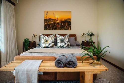 1 dormitorio con 1 cama grande y mesa de madera en Addo Alkham Lodge, en Sunland