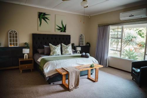 a bedroom with a large bed and a table at Addo Alkham Lodge in Sunland