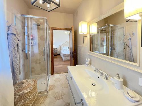 uma casa de banho com um chuveiro, um lavatório e um espelho. em Villa Villacolle by BarbarHouse em Mondolfo