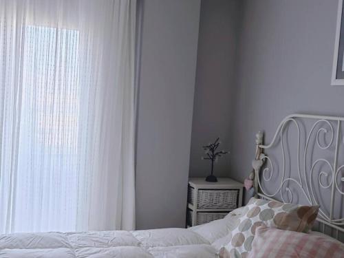 a bedroom with a white bed and a window at Rincón de Relax in Ocaña